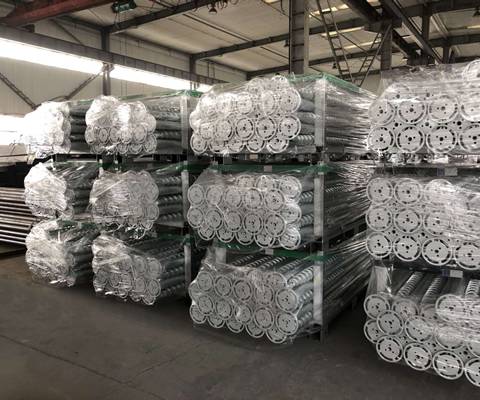 Twelve metal pallets of ground screws are placed tidily in the warehouse.